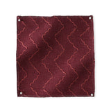 Pinned swatch of woven fabric with chevron stripe in dark red. 