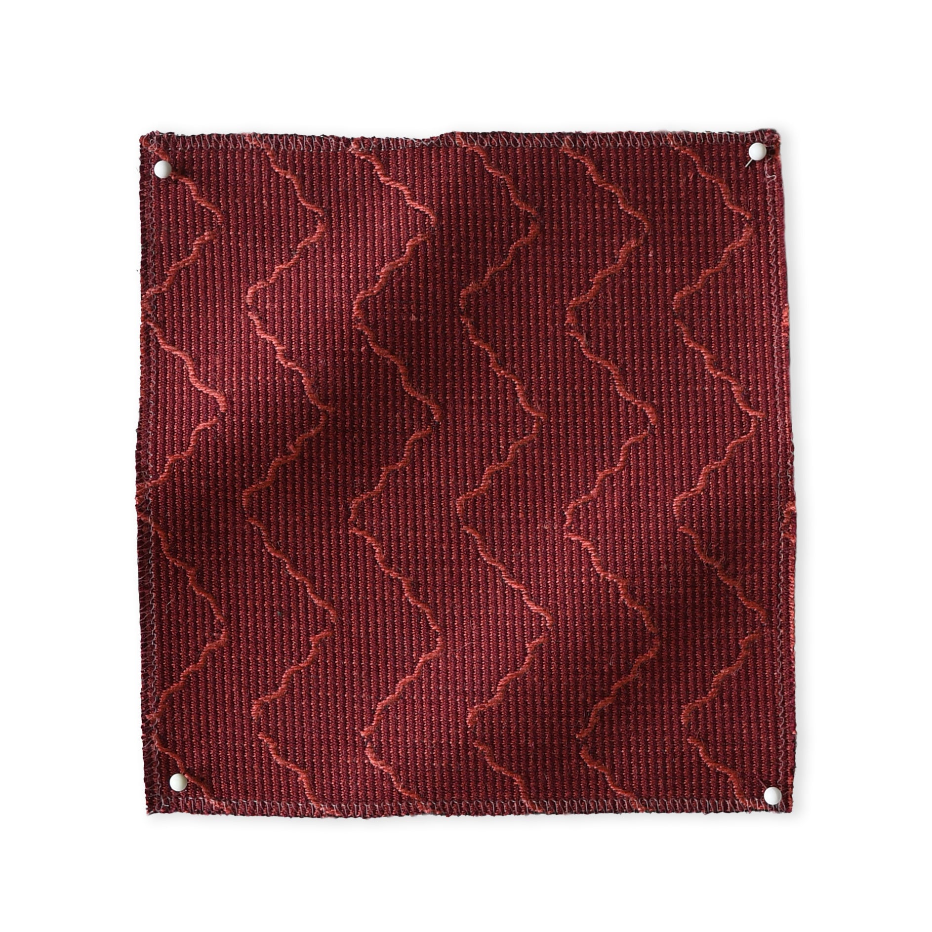 Pinned swatch of woven fabric with chevron stripe in dark red. 