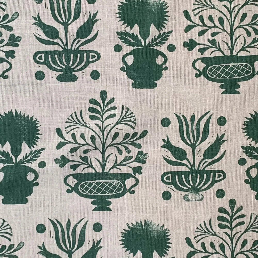 Patterned fabric with green floral and urn designs on a beige background