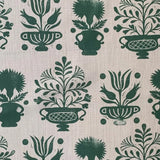 Patterned fabric with green floral and urn designs on a beige background