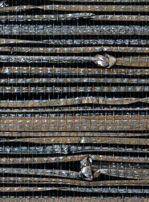 Detail of a metallic-rubbed jute grasscloth wallpaper in gray and tan on a glossy black paper.