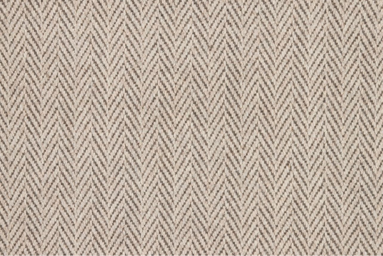 Broadloom carpet in a herringbone in cream and brown.