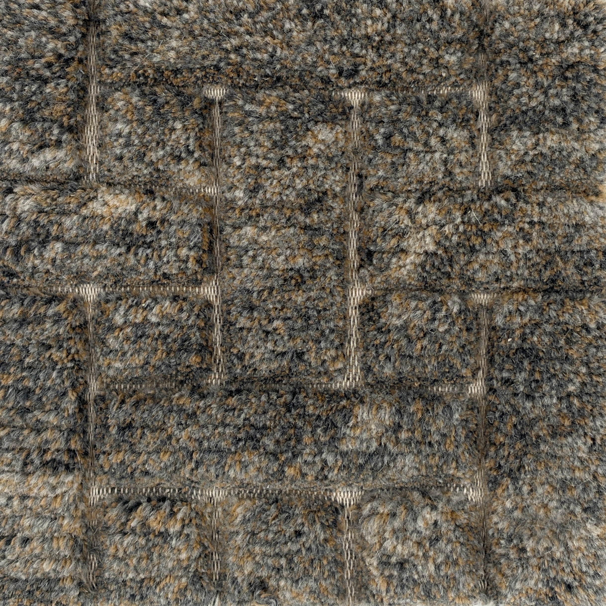 Handmade rug with a raised cut pile design in a geometric pattern in a mix of grey and tan. 