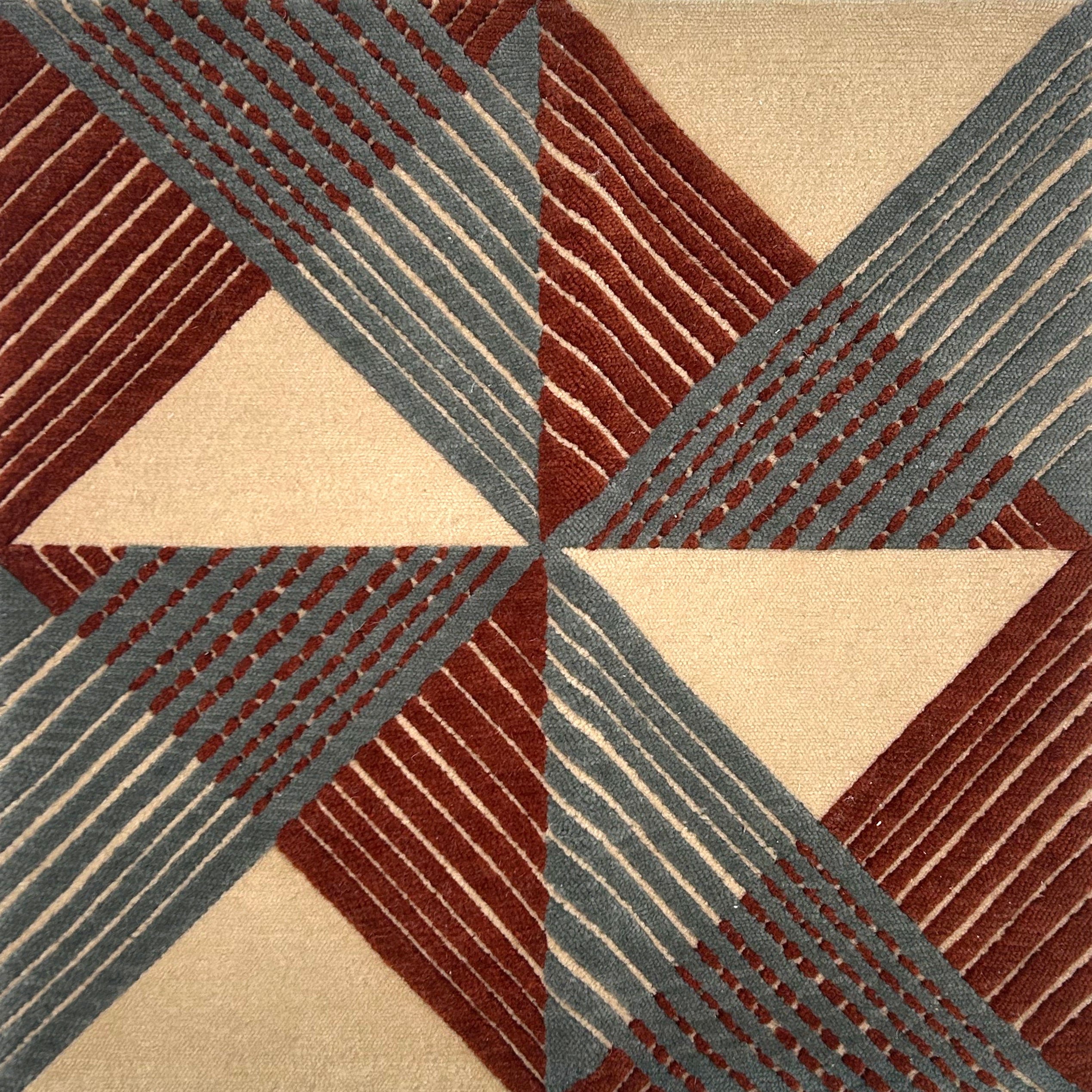 Handknotted rug in a geometric grid design in cream, red and slate blue. 
