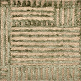 Detail of handknotted wool and silk with a raised green geometric pattern against a natural brown background.