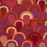Patterned rug with scallop shapes in shades of red, purple, pink and cream. 