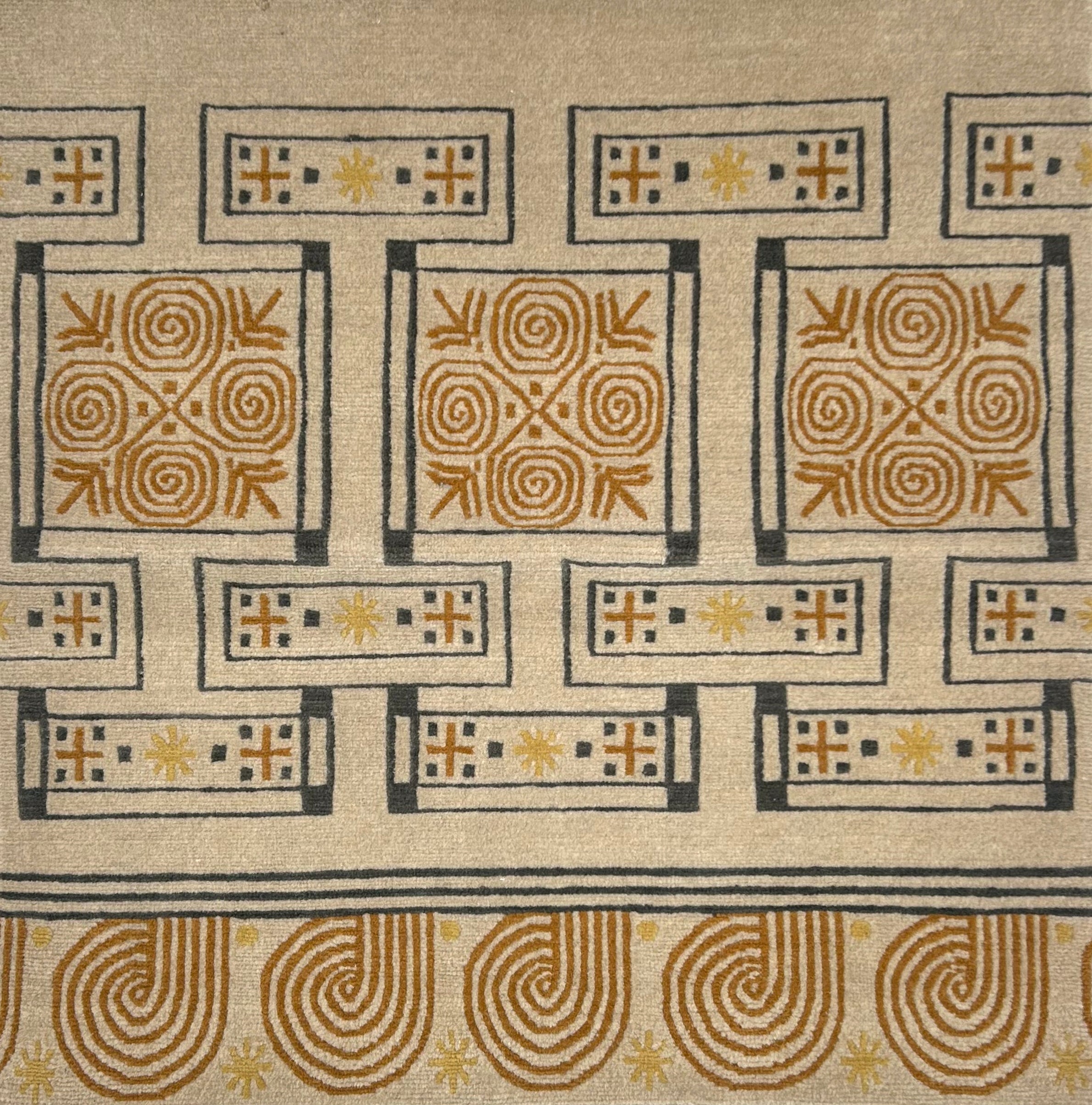 Handknotted rug in an ornate geometric design in yellow, tan and grey on a cream field. 