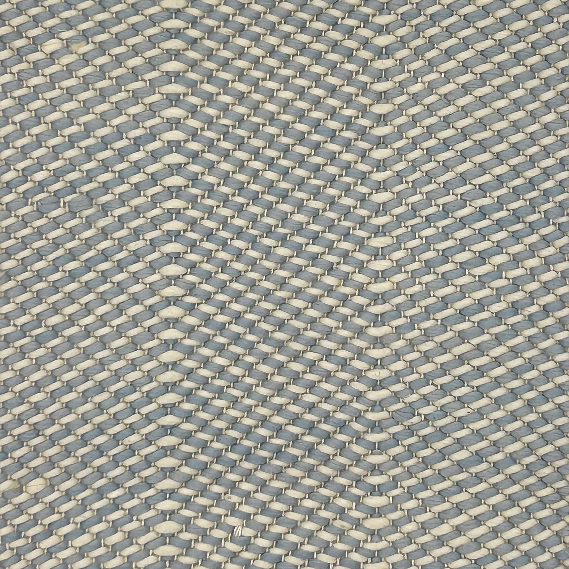 Textured flatweave rug with a blue and beige zigzag design