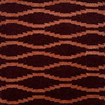 Hand knotted rug with a wavy line in orange on a maroon field. 