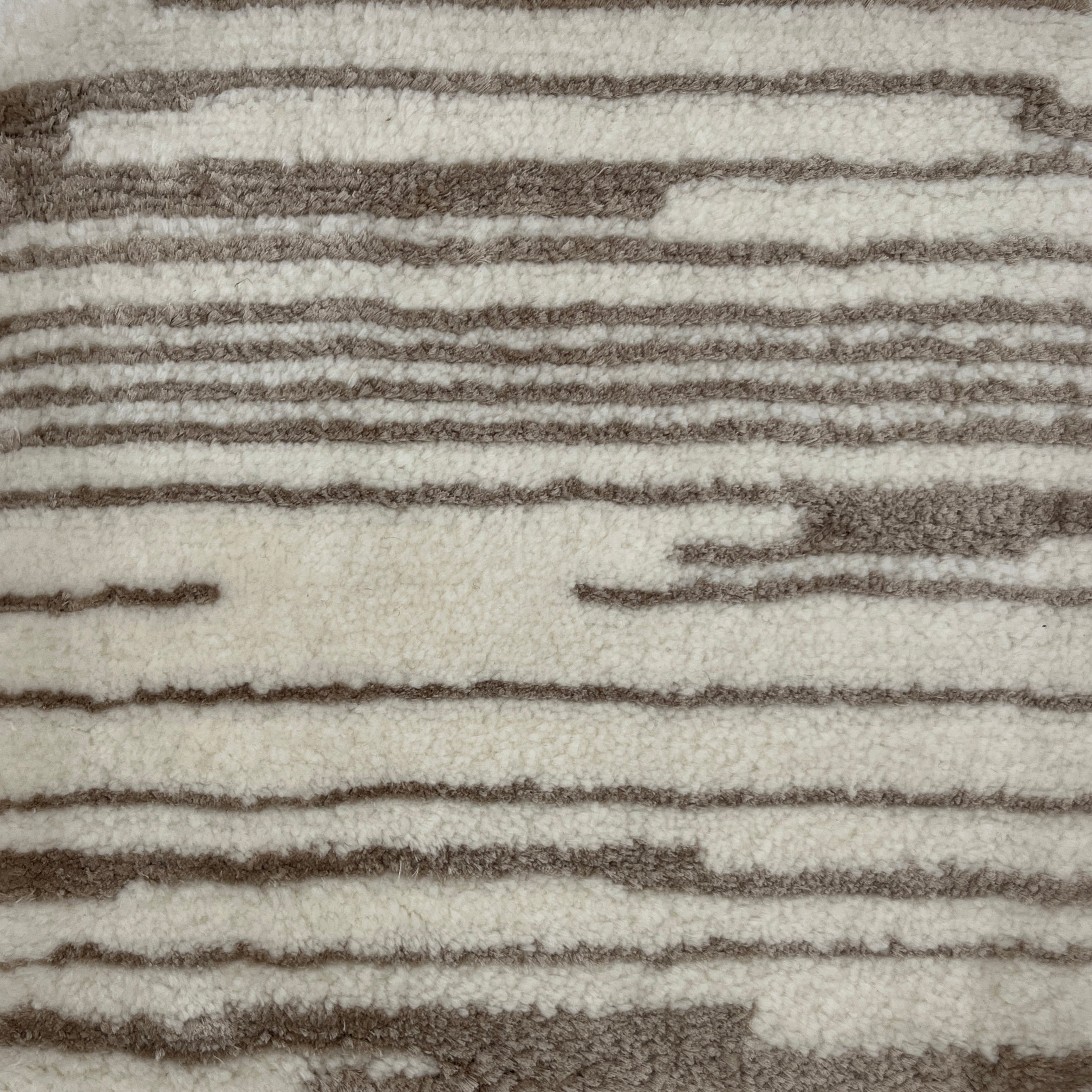 Close-up of a textured rug with brown and beige stripes