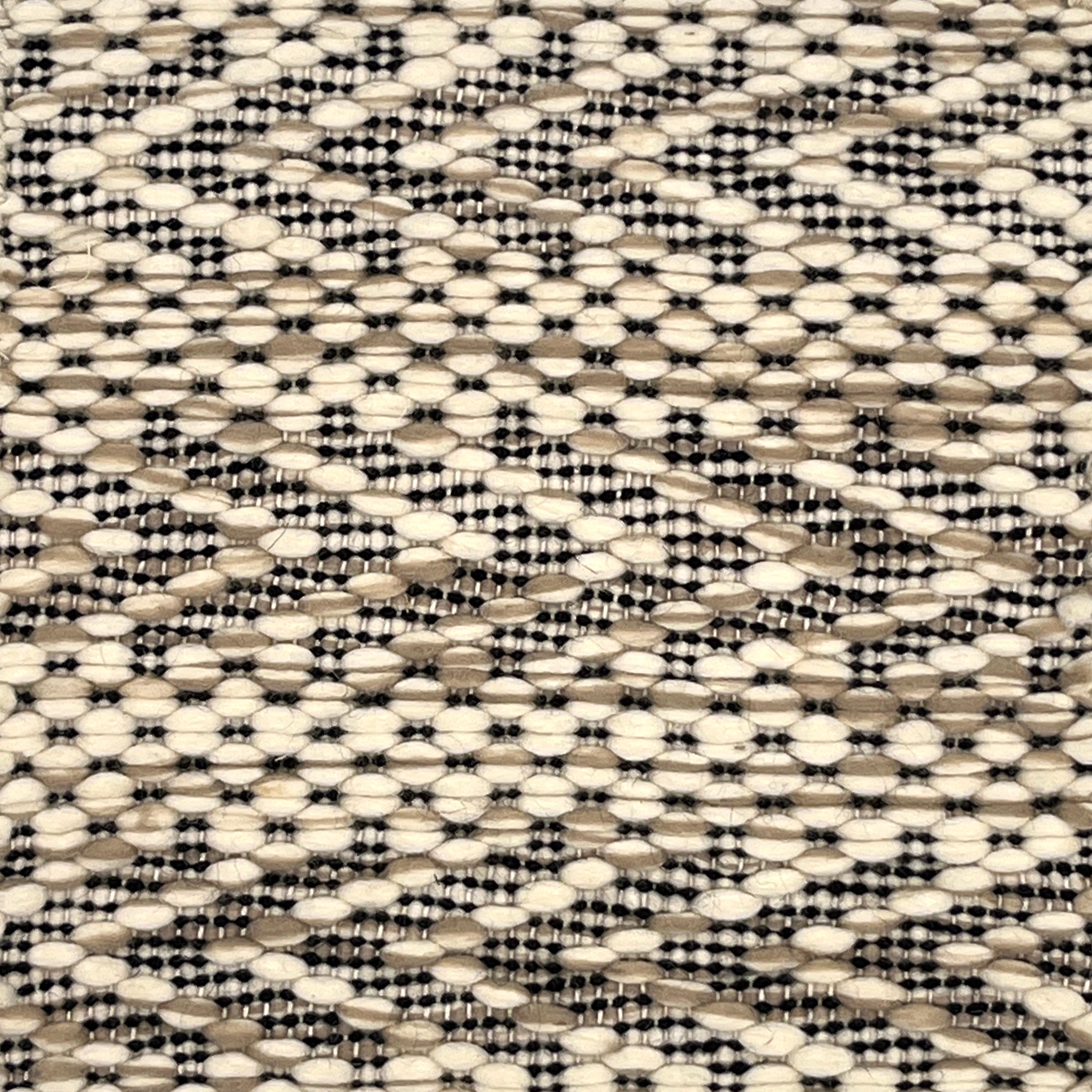Flatweave rug with graphic herringbone pattern in cream and tan with black accents.