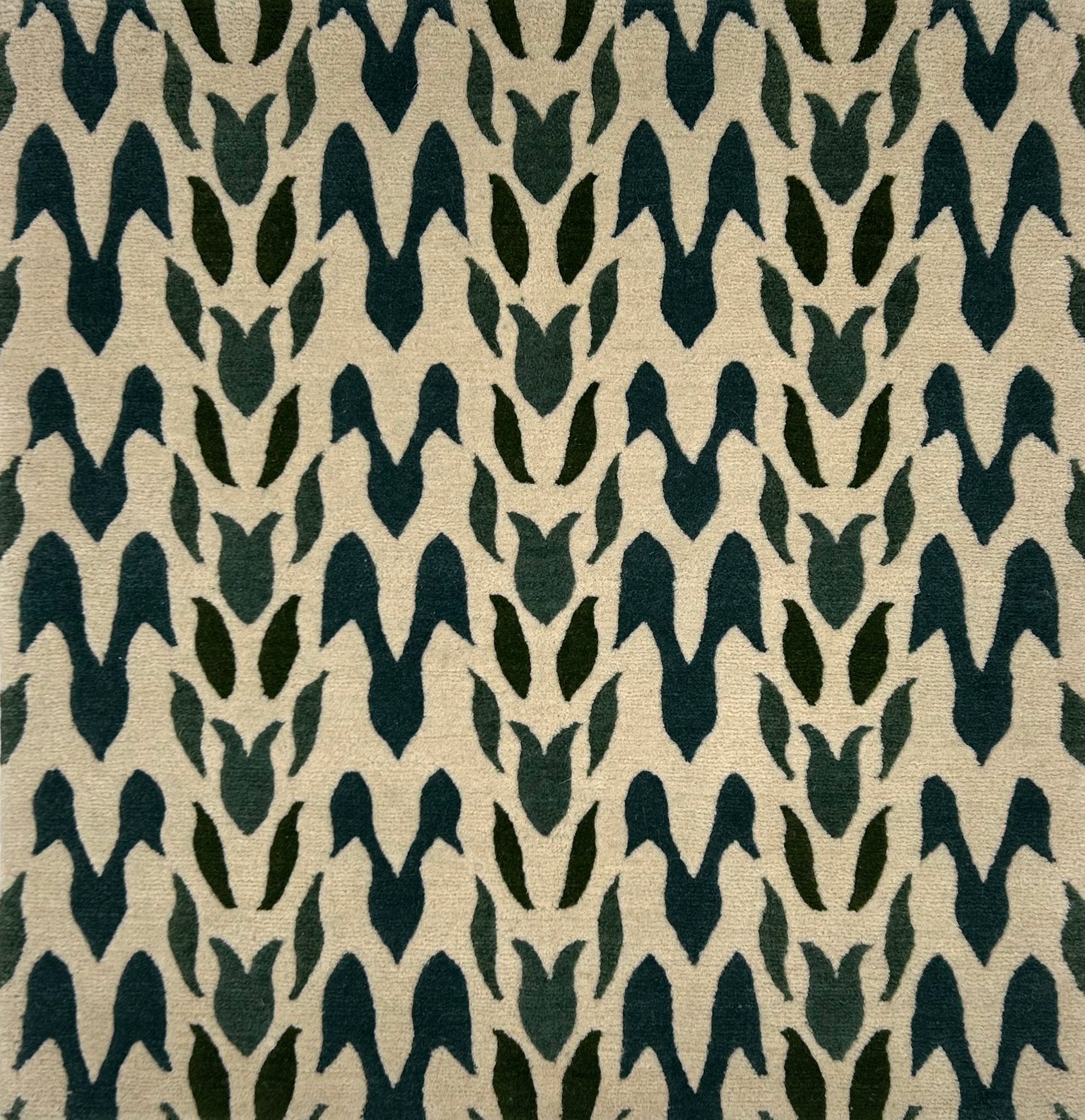Handknotted rug in a petal pattern in shades of dark green on cream. 