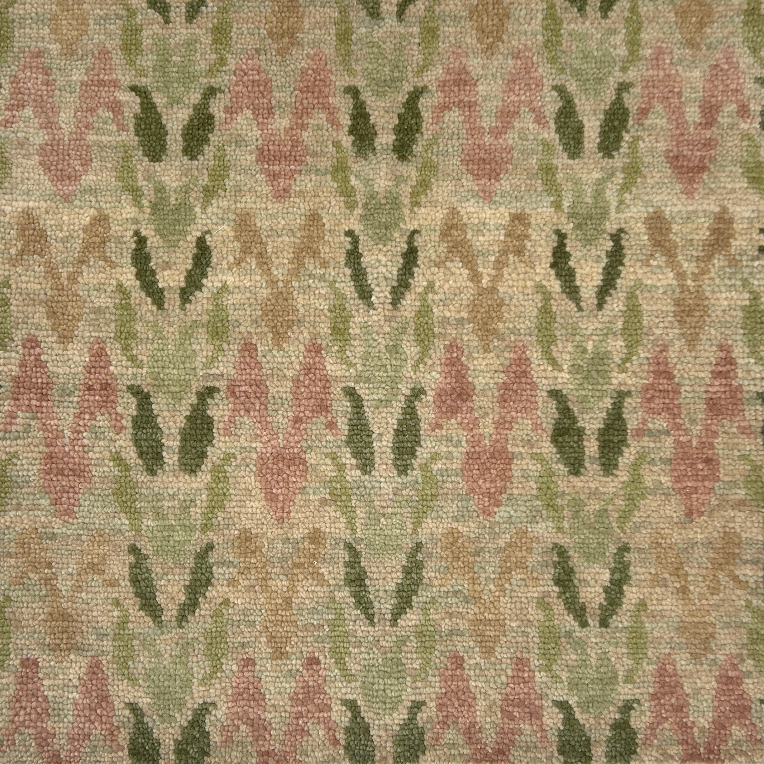 Textured rug with a pattern of pink flowers and green leaves on a beige background