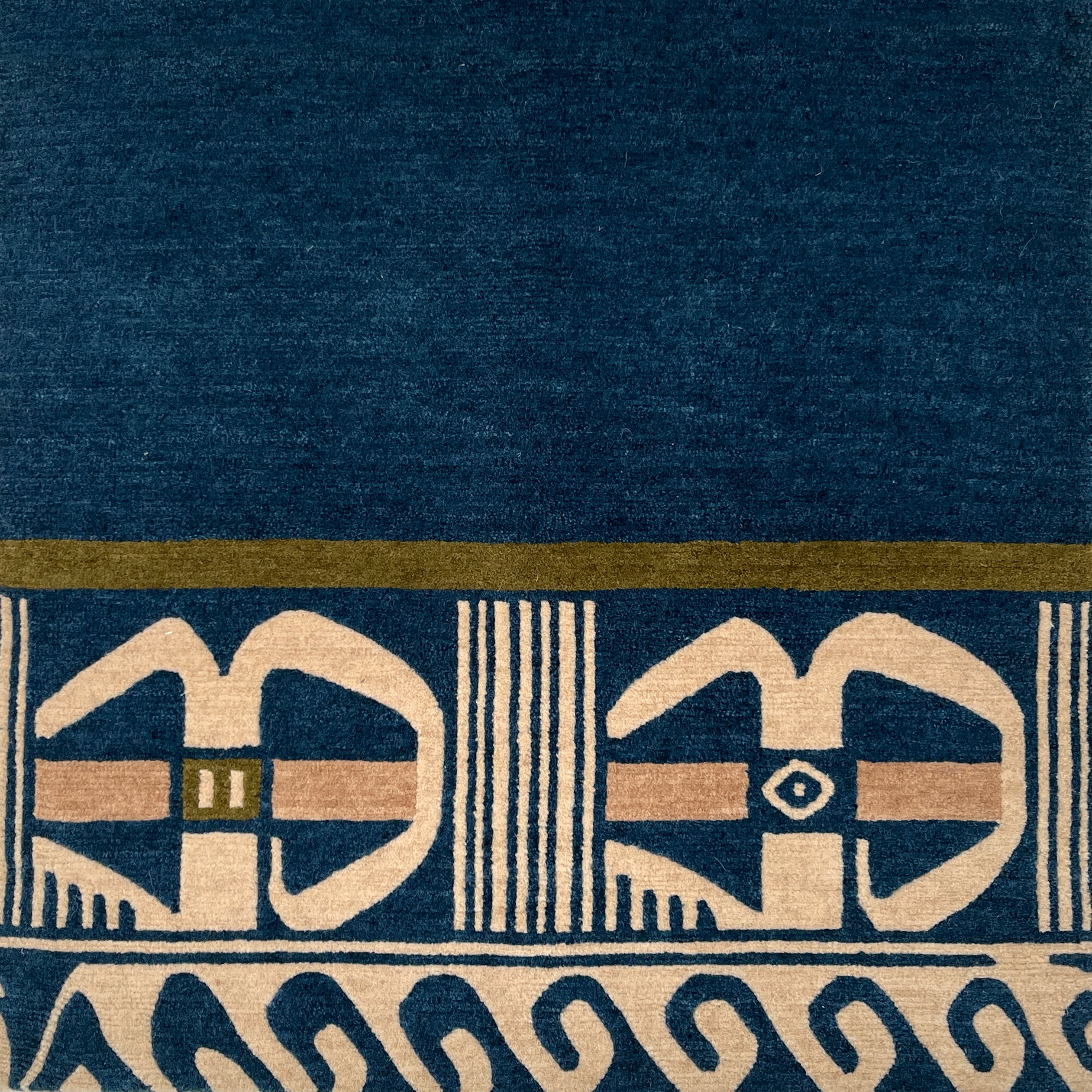 Close-up of a blue carpet with beige geometric patterns