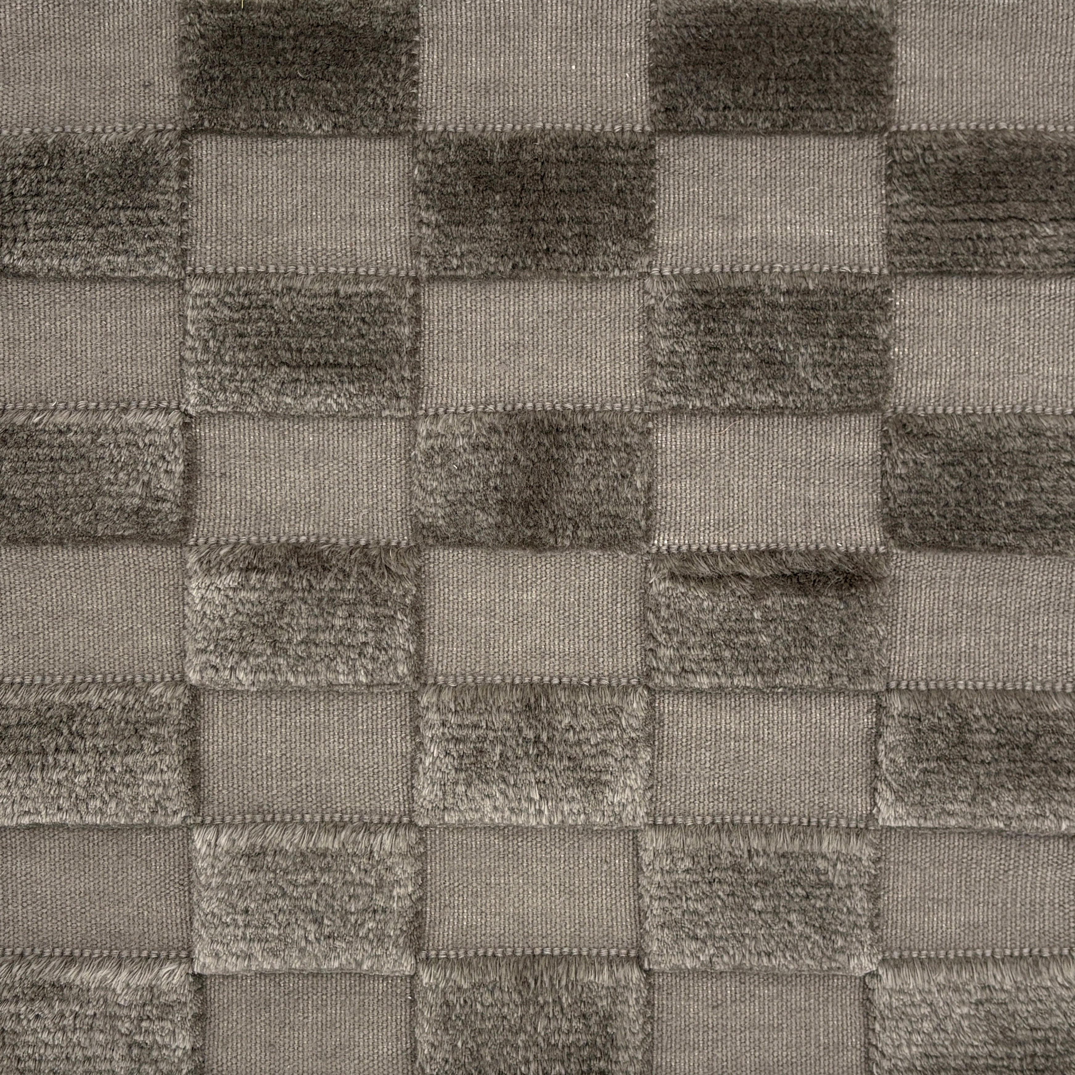 Handwoven rug with raised checkerboard cut pile squares in grey