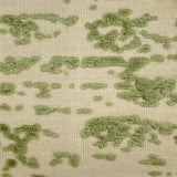 Textured flatweave rug with green pattern on a beige background