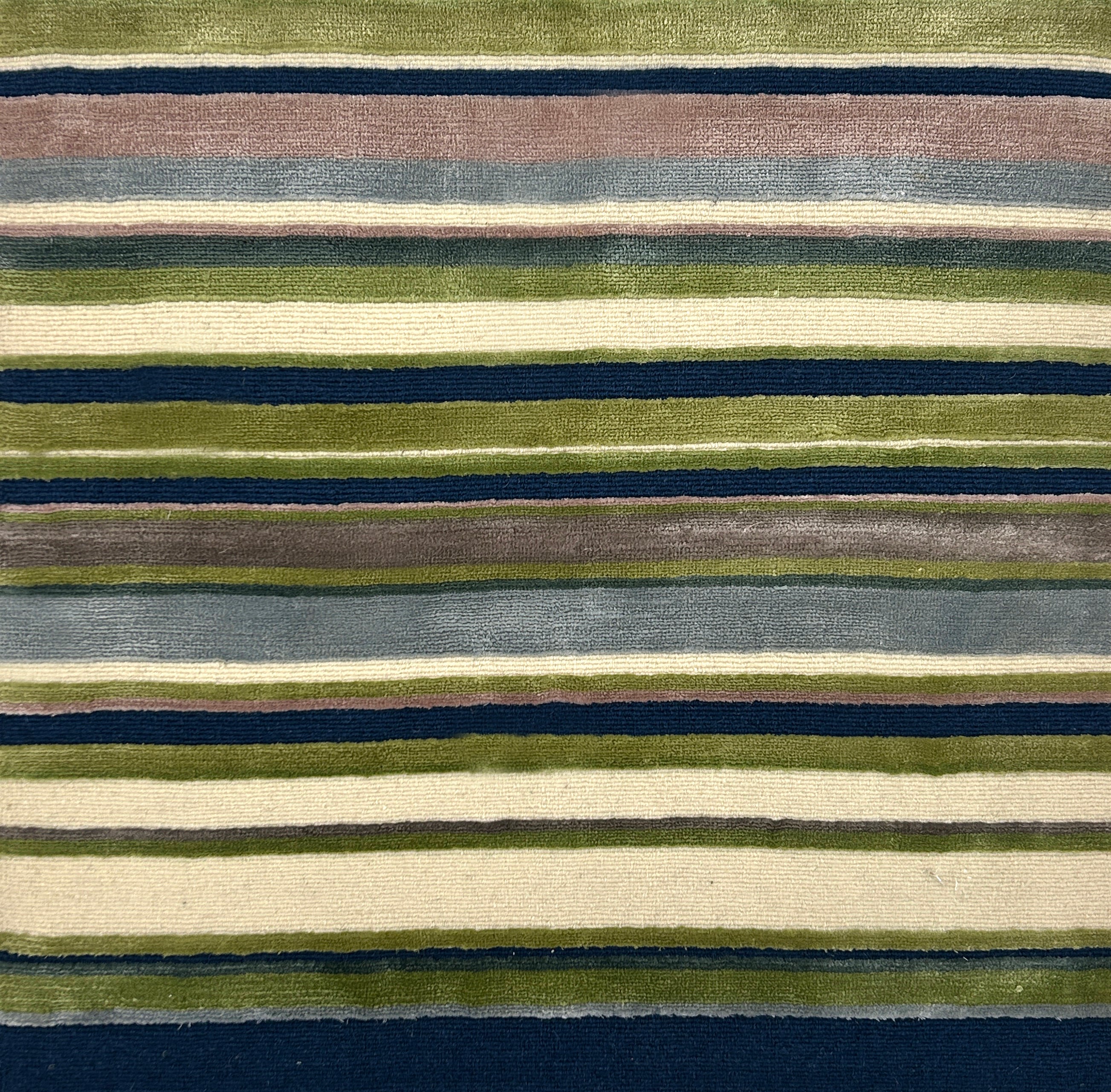 Striped rug with a pattern of green, blue, and beige stripes on a dark blue background.