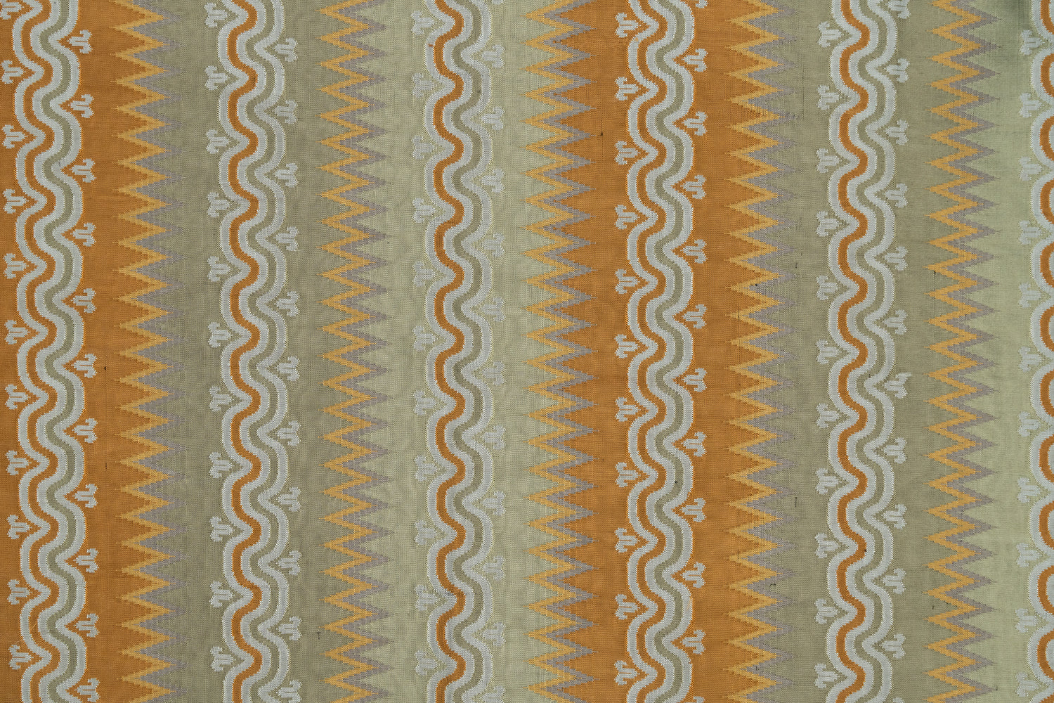 Handwoven silk fabric with wavy lines in orange, yellow, sage green and white. 