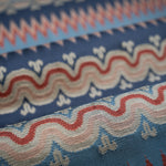 Close-up of fabric with red, white, and blue wavy stripe pattern. 