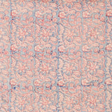 Detail of fabric in a floral block print in cream and red on a blue field.