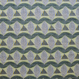 A close-up of a patterned fabric featuring repeating rows of stylized grey leaves, blue and yellow stripe triangles and wavy blue-yellow lines on yellow background.
