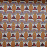 A close-up of a patterned fabric featuring repeating rows of stylized orange leaves, navy and red striped triangles and wavy orange-blue lines on a white background
