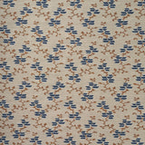 A close-up of a woven fabric pattern featuring a repeating geometric design of blue diamond floral shapes and brown branch motifs on a warm beige background.
