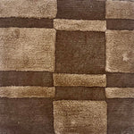 A brown rug with raised pile taupe squares and rectangles.