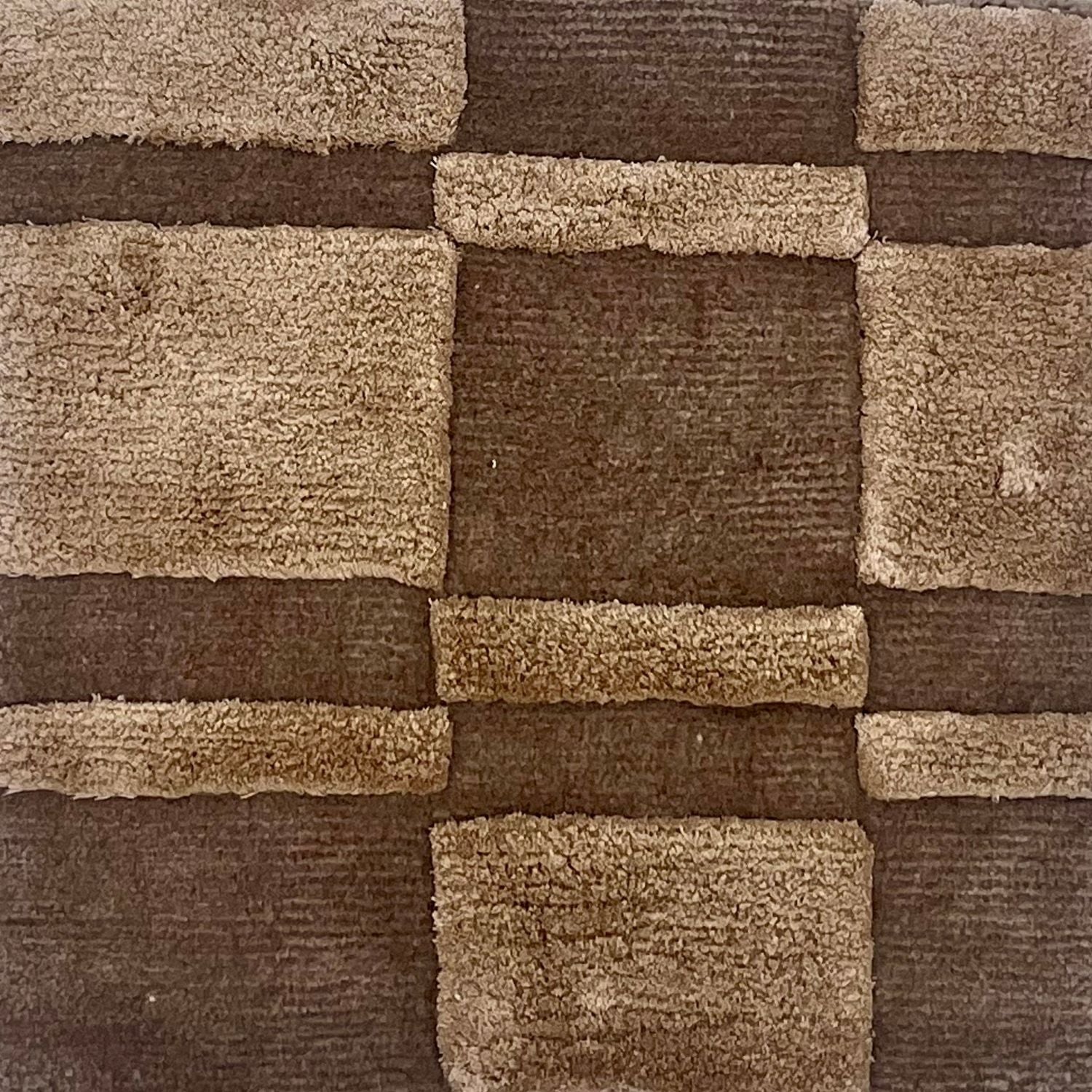 A brown rug with raised pile taupe squares and rectangles.