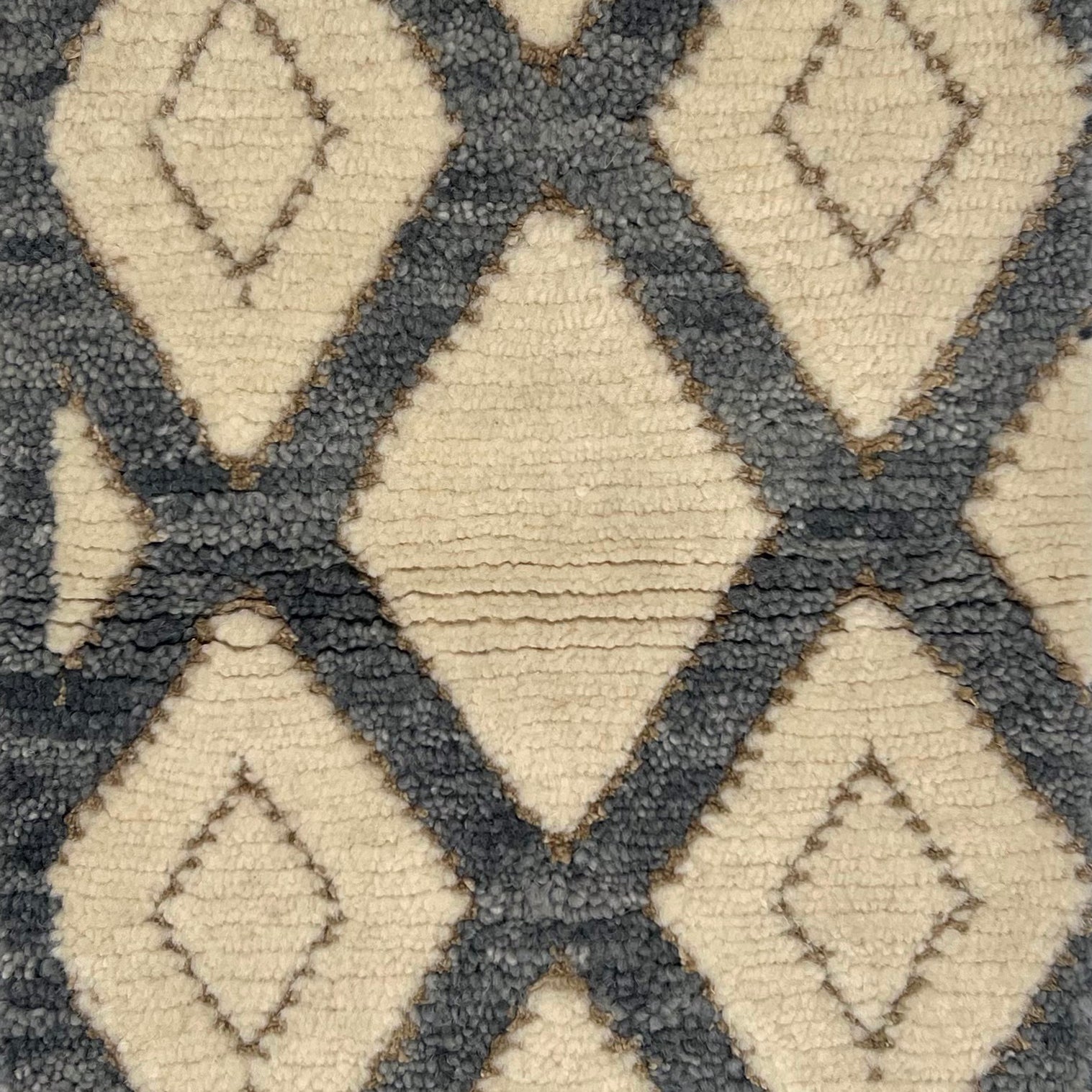 Handknotted cut pile rug in a grey lattice on a white field with inset taupe diamond accents. 