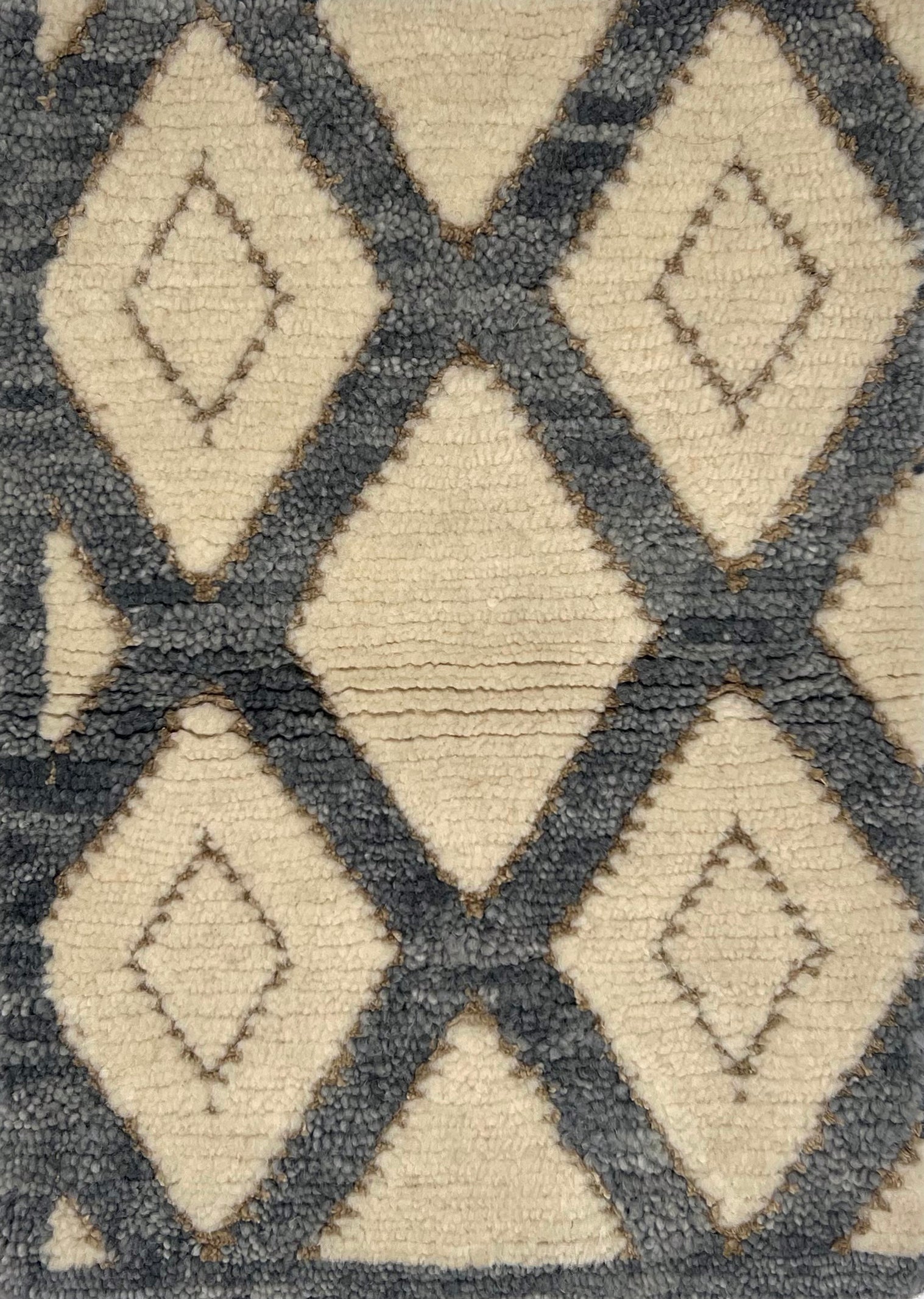 Handknotted cut pile rug in a grey lattice on a white field with inset taupe diamond accents. 
