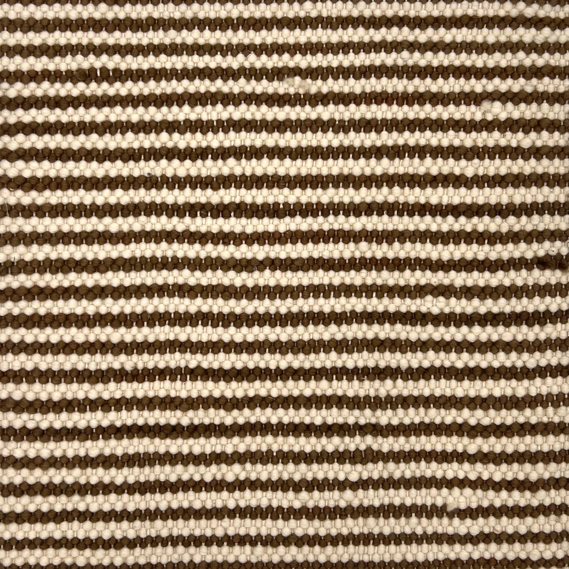 Flatweave rug in a knobby texture in thin brown and cream stripes. 