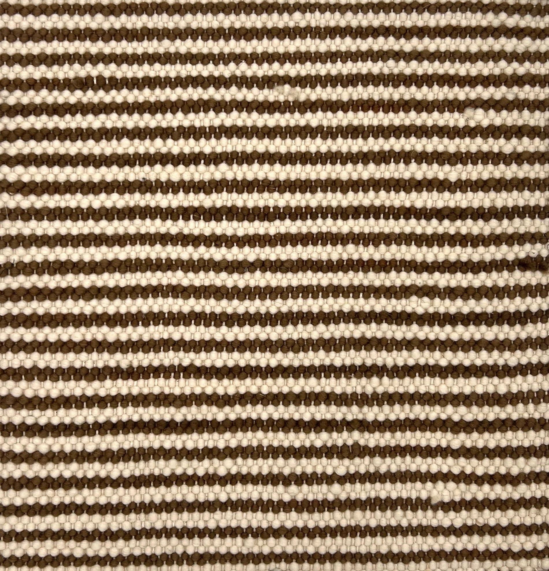 Flatweave rug in a knobby texture in thin brown and cream stripes. 