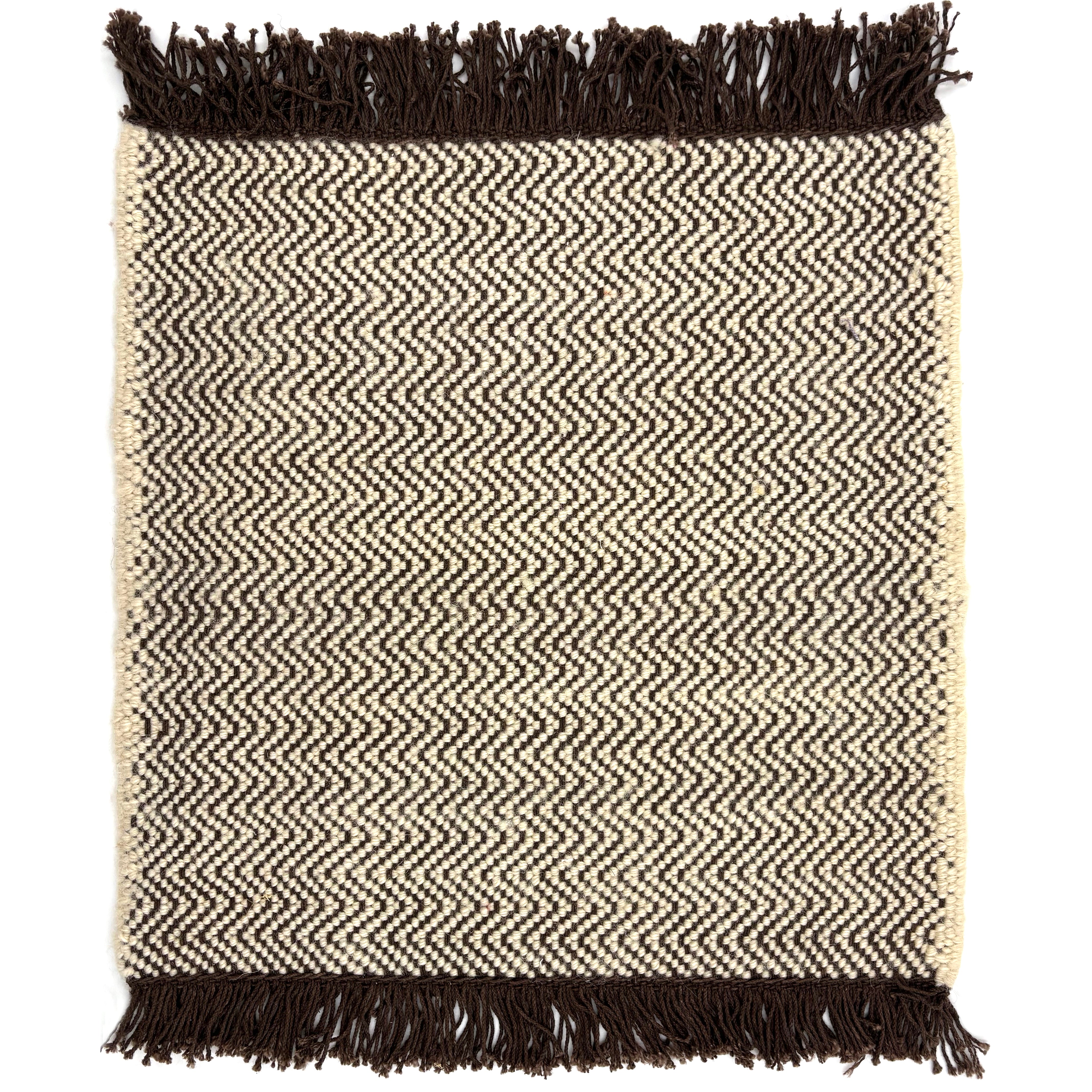 Handwoven rug in a chevron stripe in cream and chocolate brown with fringed edges.