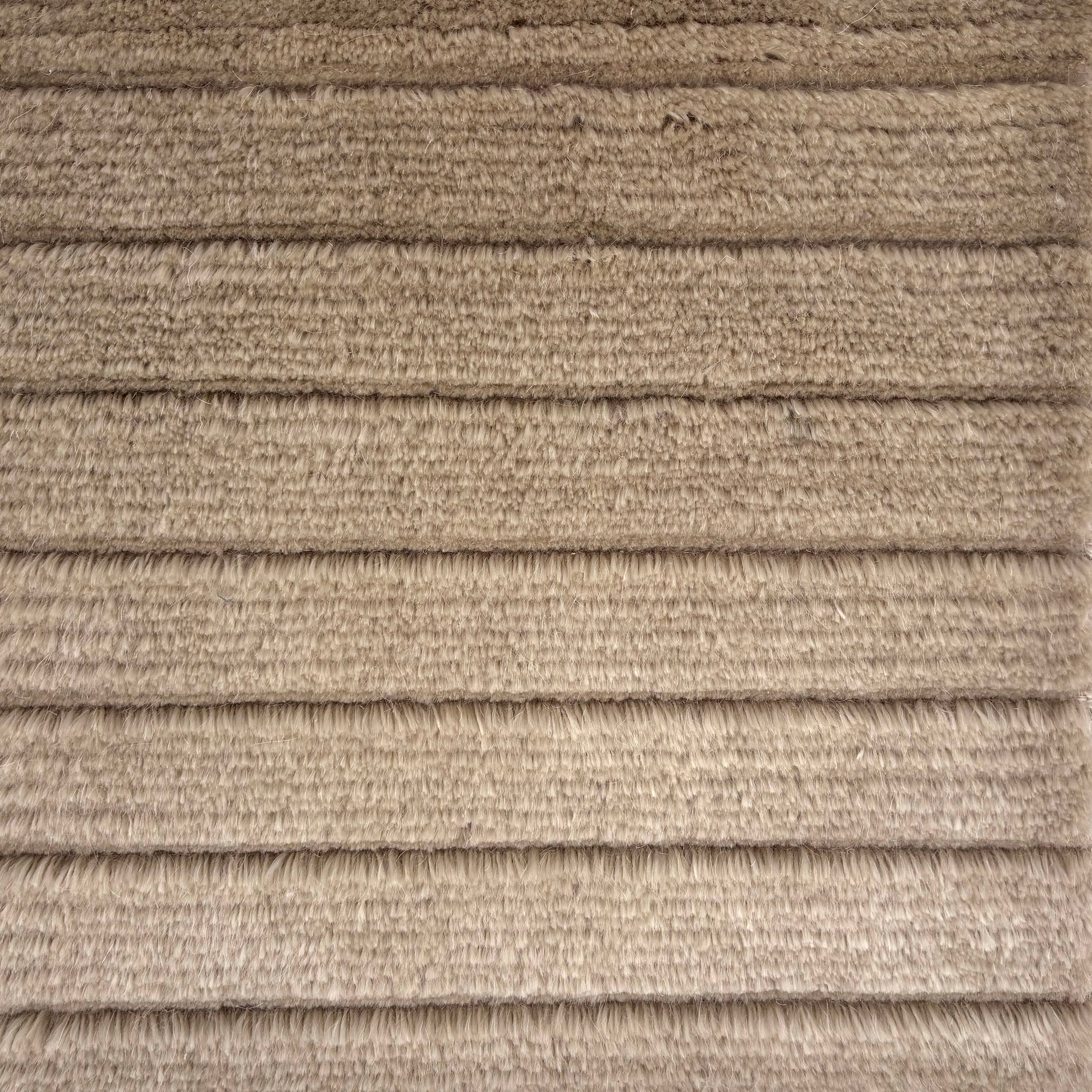 Handknotted rug in a cut pile & loop stripe in taupe.