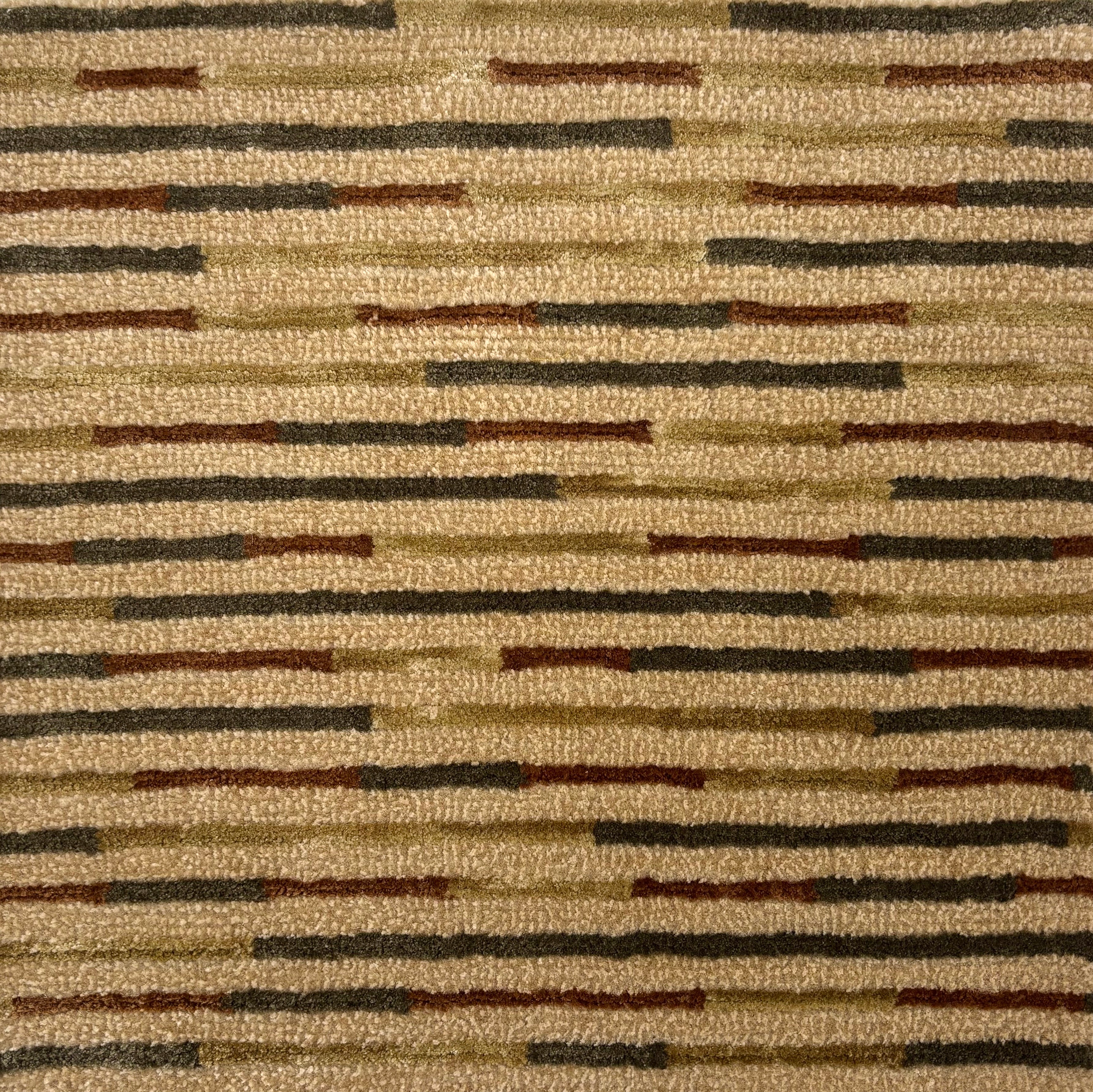 Handknotted rug in a varied silk stripe pattern of green, brown and tan on a tan field. 