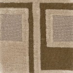 Close-up of a textured area rug with a geometric pattern in taupe, beige, and dark brown.