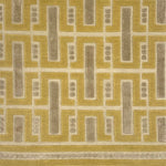 Close-up of a handknotted geometric rug with yellow and ecru colors. 