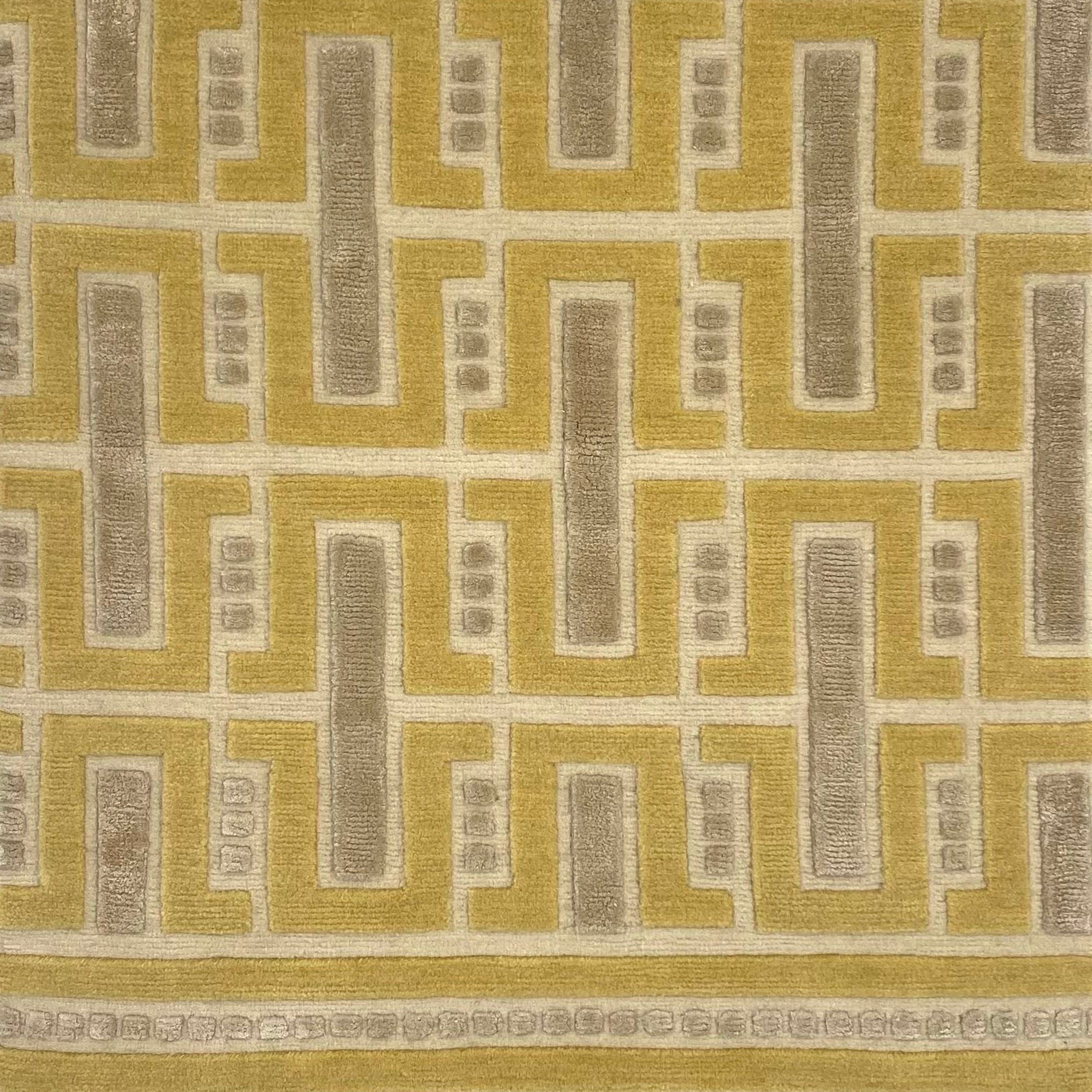 Close-up of a handknotted geometric rug with yellow and ecru colors. 