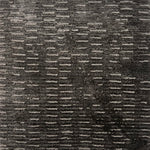 Handknitted rug in a textural linear design in shades of grey. 