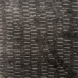 Handknitted rug in a textural linear design in shades of grey. 