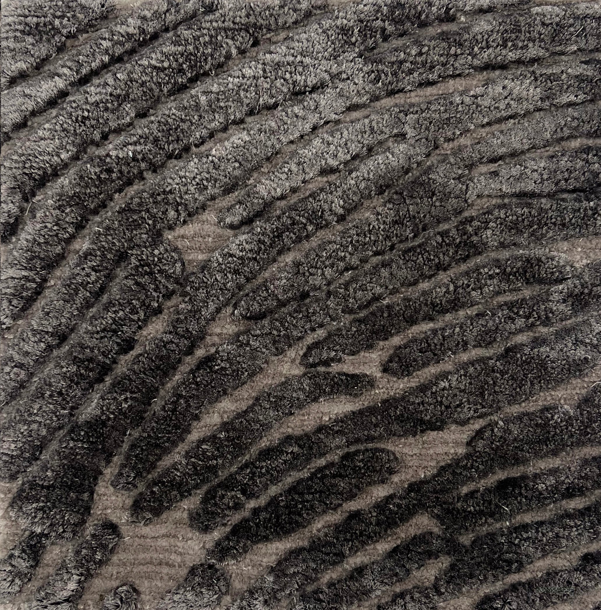 Handknotted rug with a raised abstract linear design in shades of grey. 