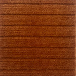 Handknotted rug in a wide raised cut pile stripe in rust wool. 