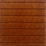 Handknotted rug in a wide raised cut pile stripe in rust wool. 