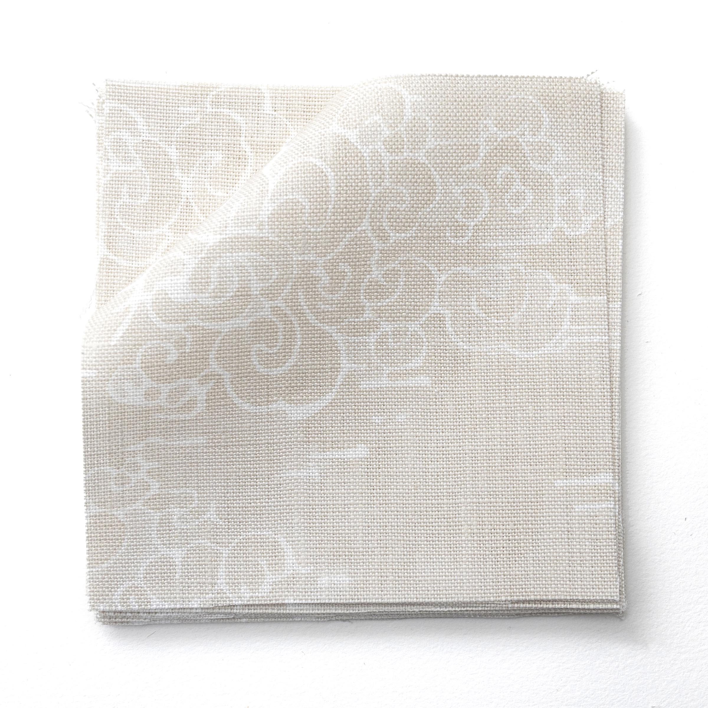 Fabric swatches in a painterly cloud pattern in white on a beige watercolor field.