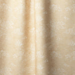 Draped fabric a painterly cloud pattern in white on a pastel yellow watercolor field.