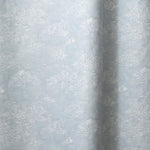 Draped fabric a painterly cloud pattern in white on a pastel blue watercolor field.