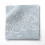 Fabric swatches in a painterly cloud pattern in white on a pastel blue watercolor field.