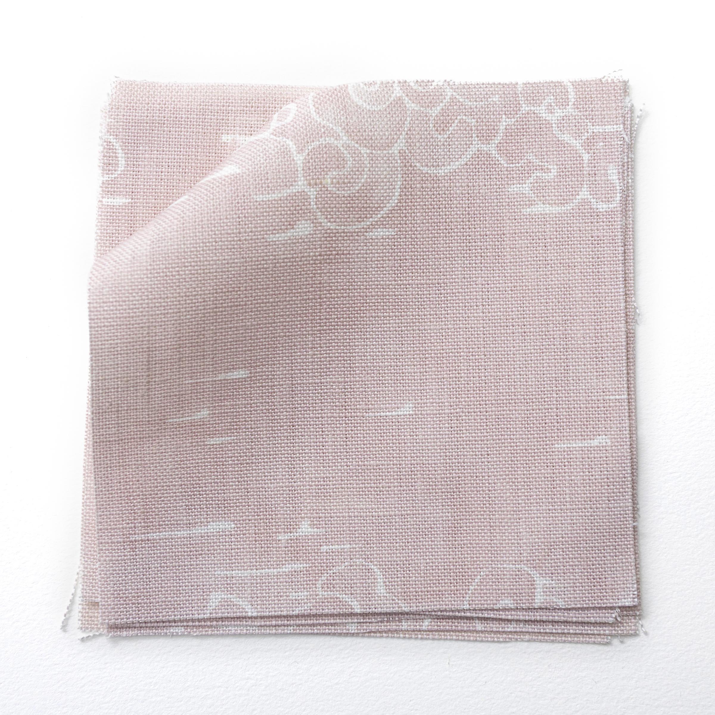 Fabric swatches in a painterly cloud pattern in white on a pastel pink watercolor field.