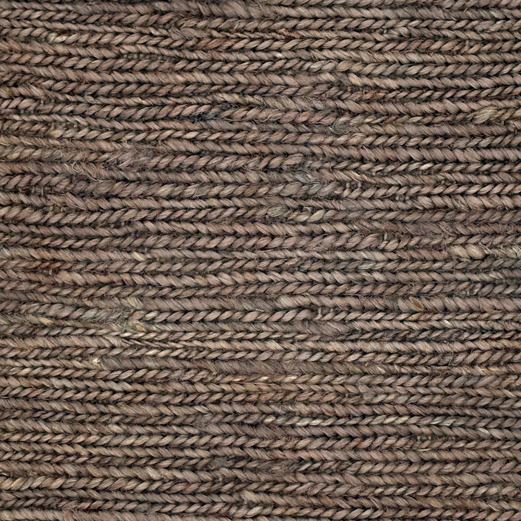 Close up of a rug in a sumak weave in brown-grey